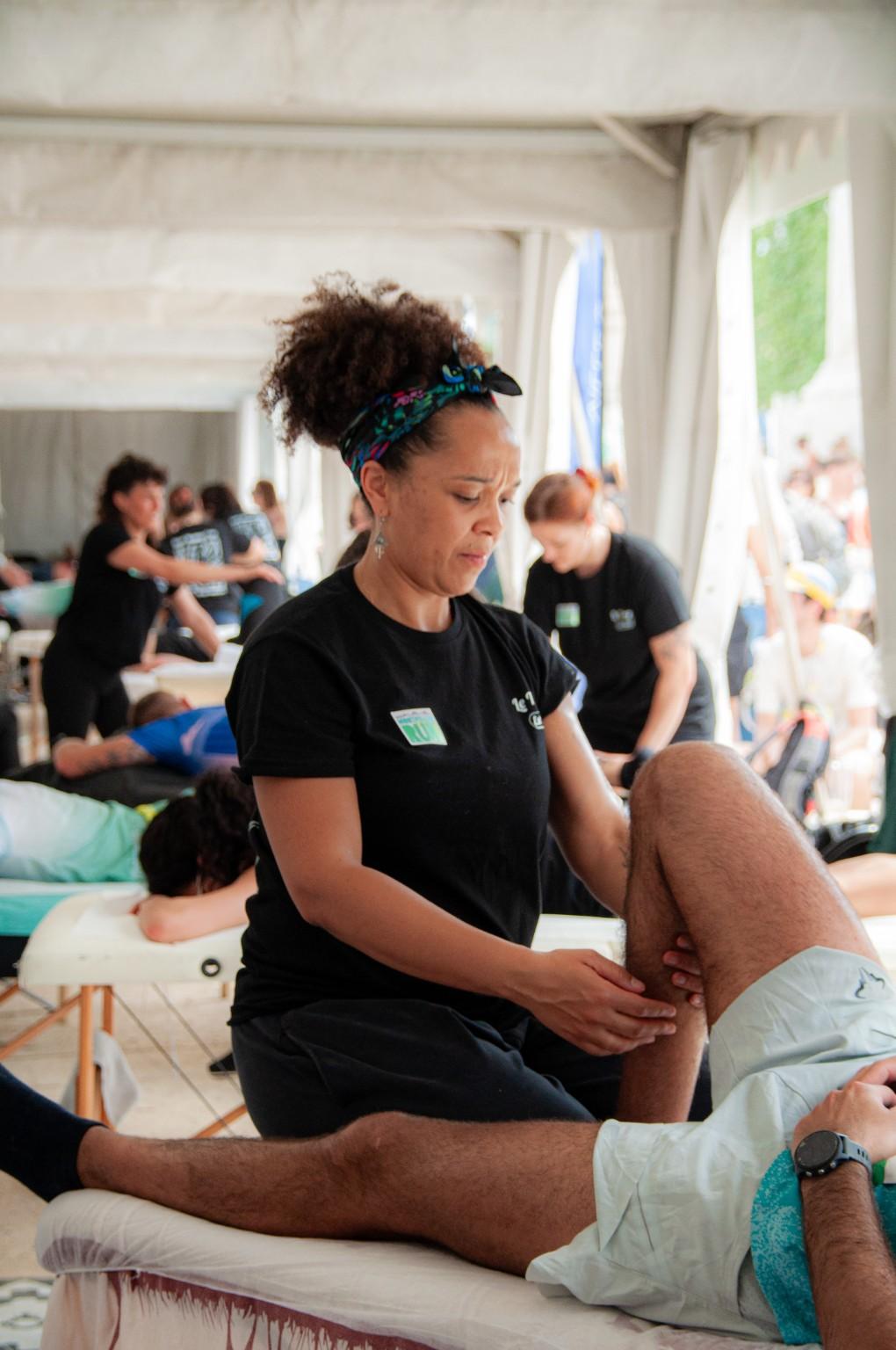 Lysa travaillant sur la jambe d’un participant à un événement sportif